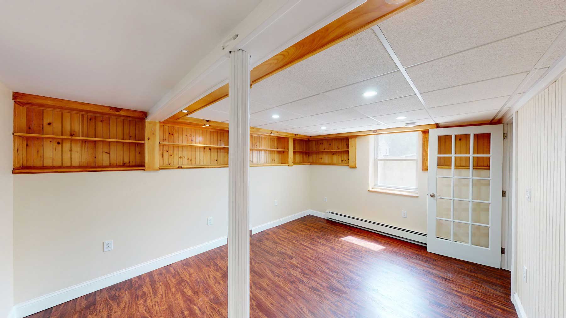 Interior view of a room featuring wooden shelving and a door with glass panels.